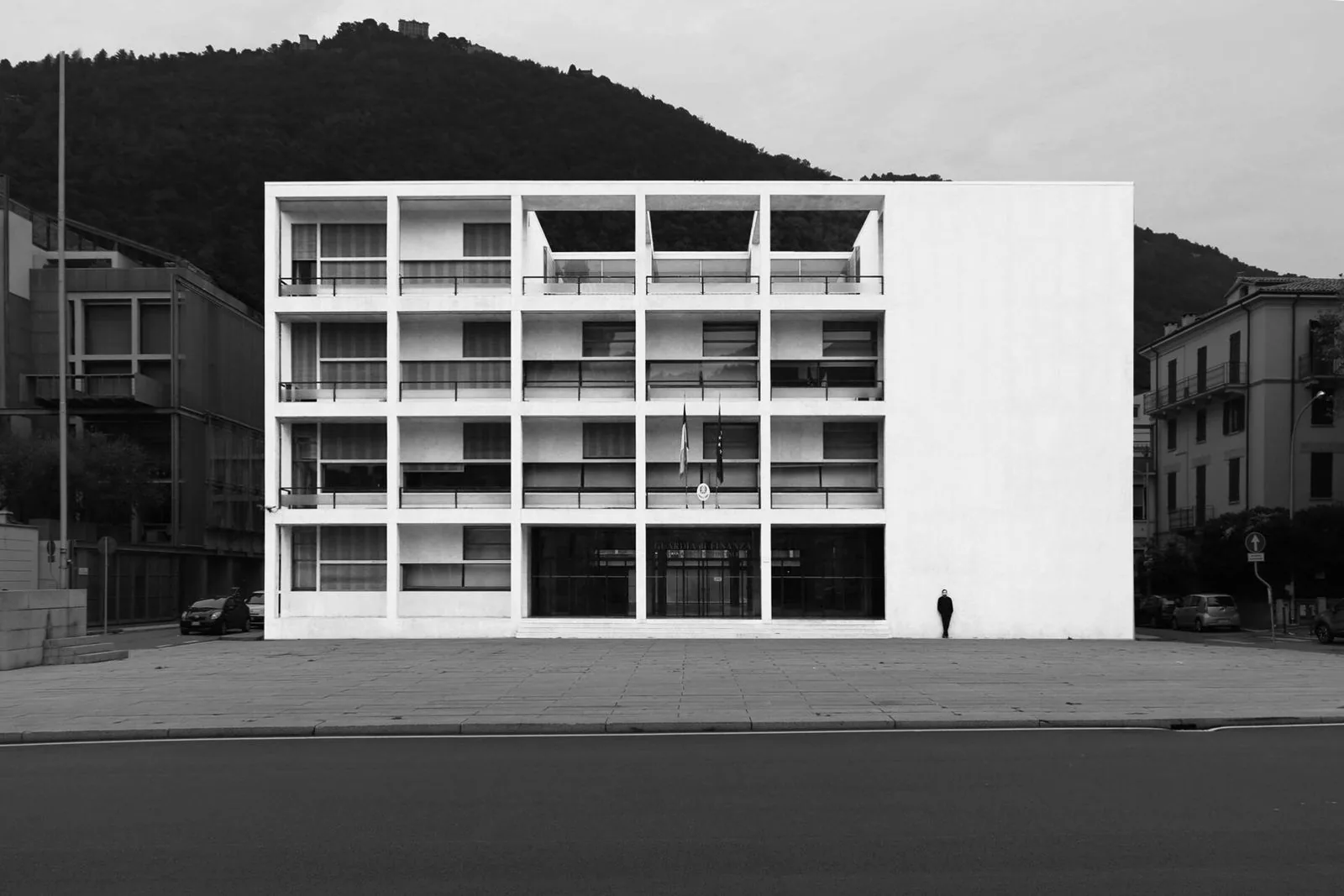 Facciata dell'ex Casa del Fascio di Giuseppe Terragni a Como in bianco e nero, con la collina alle spalle