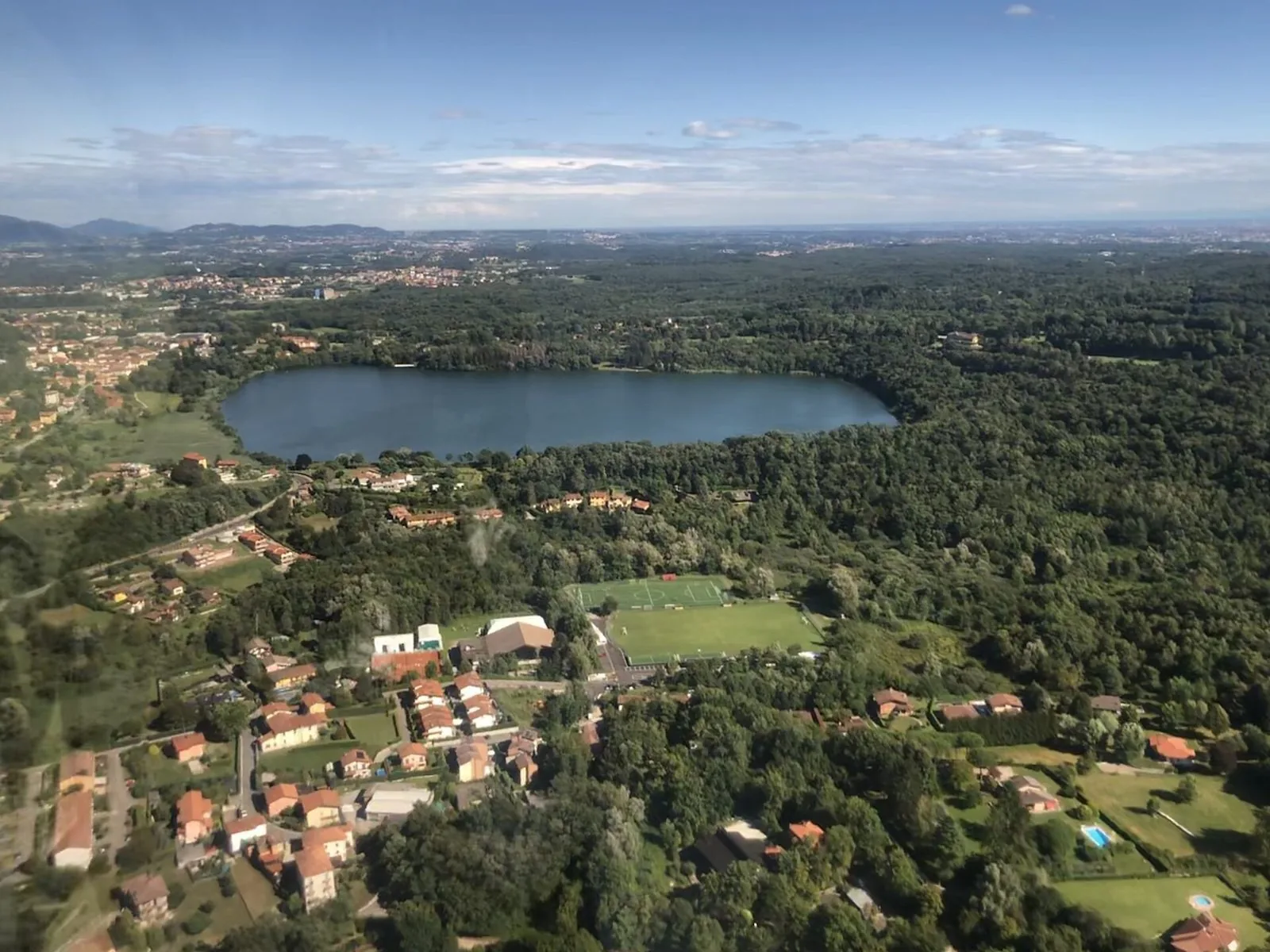 Veduta aerea del Lago di Montorfano circondato dai boschi, nei pressi del Circolo Golf Villa d'Este